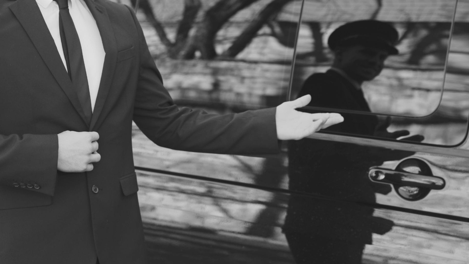 Professional chauffeur welcoming a client with airport signage