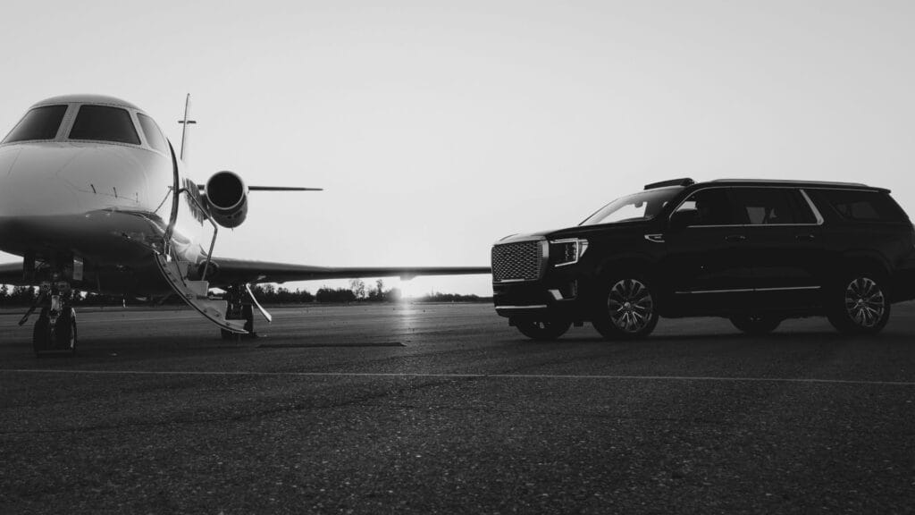 Luxury GMC Yukon parked beside a private jet for airport transfer service